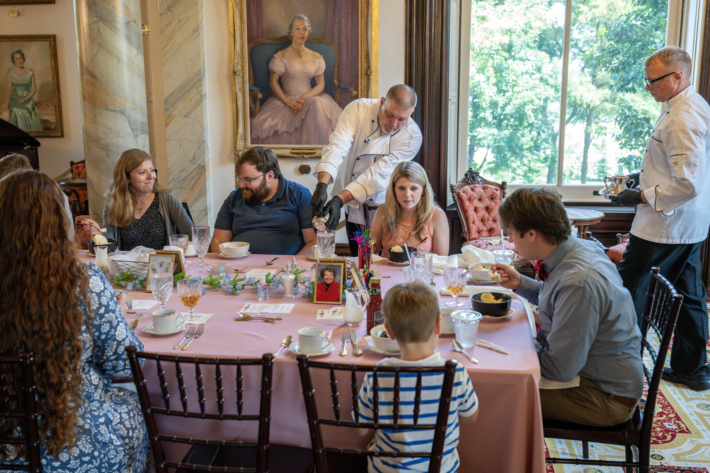 Work-release participants serve guests at the Governor's Mansion. The menu consists of a mixed greens salad with carrots, cucumbers, tomatoes, mozzarella and house-made buttermilk dressing; pan-seared garlic chicken with a white wine cream sauce; creamy mashed potatoes; and green beans almondine. Dessert is birthday cake and Central Dairy vanilla ice cream.