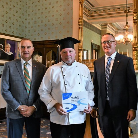 Governor Mike Kehoe, Jeremy Burton and Myles Strid, director of the Division of Adult Institutions