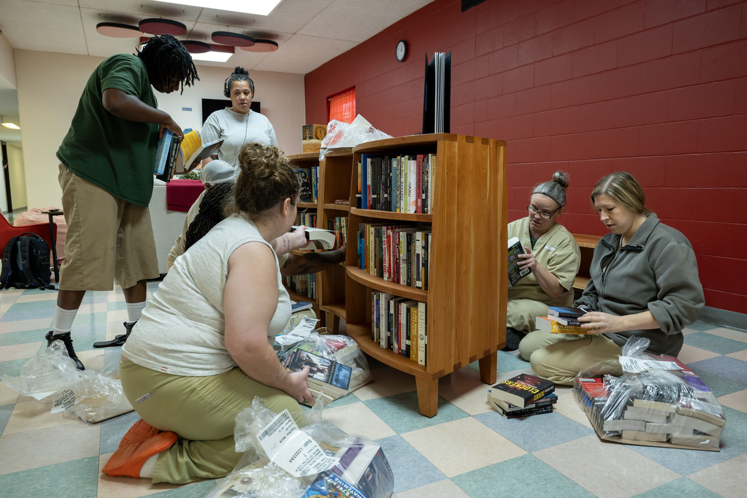 Residents place new paperback books in the Freedom Reads bookcase.