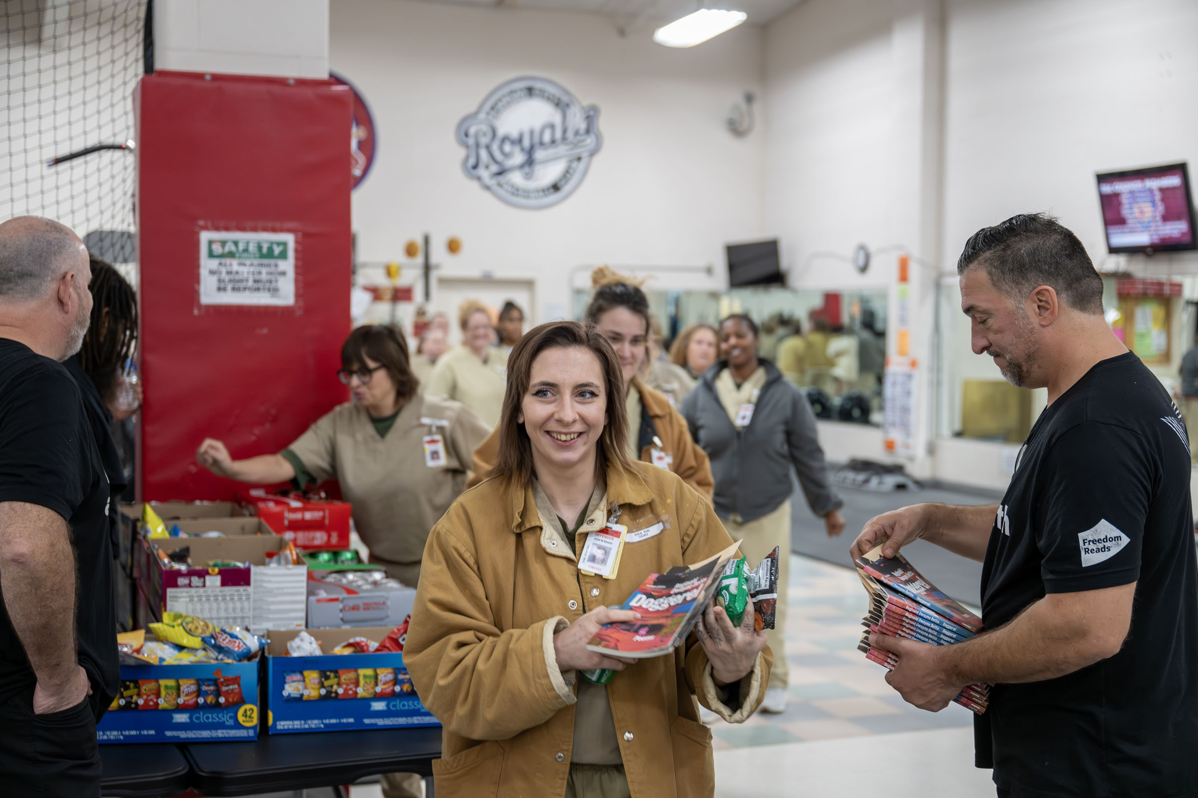 Attendees of the poetry reading by Reginald Dwayne Betts line up to receive snacks and books provided by Freedom Reads.