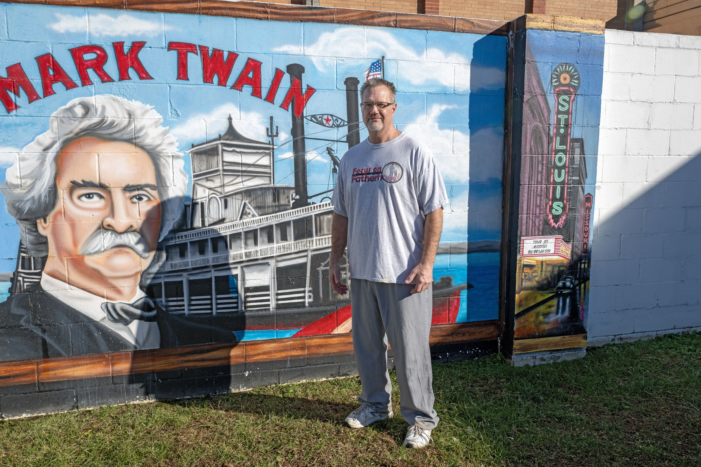 Brian Cox stands in front of his mural depicting the Mark Twain Riverboat