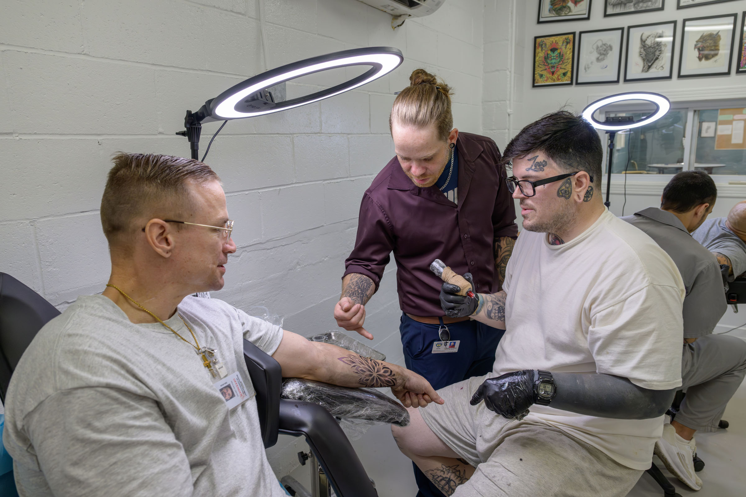 Instructor points out details on the arm of a seated client.