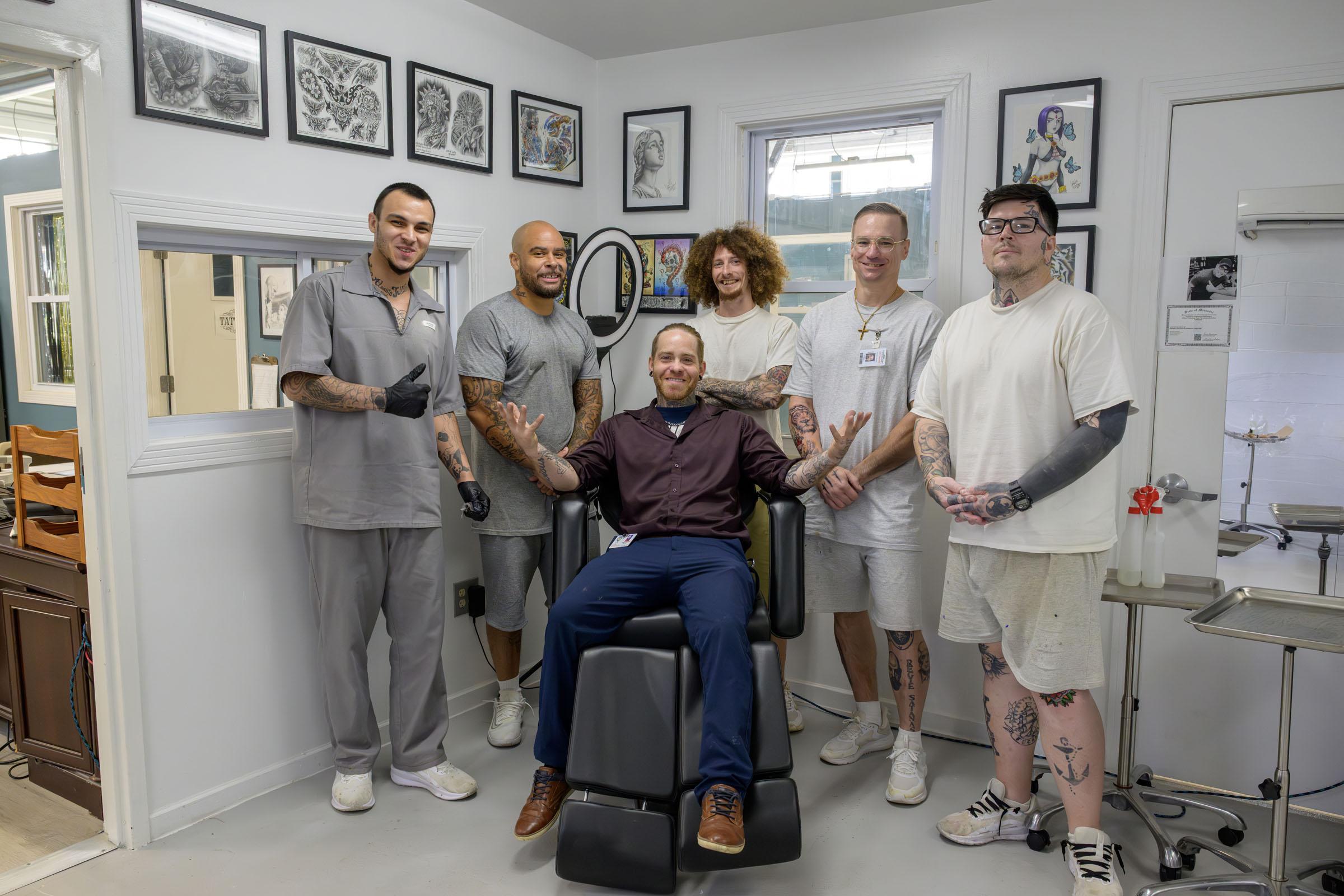Instructor sits in chair surrounded by students.