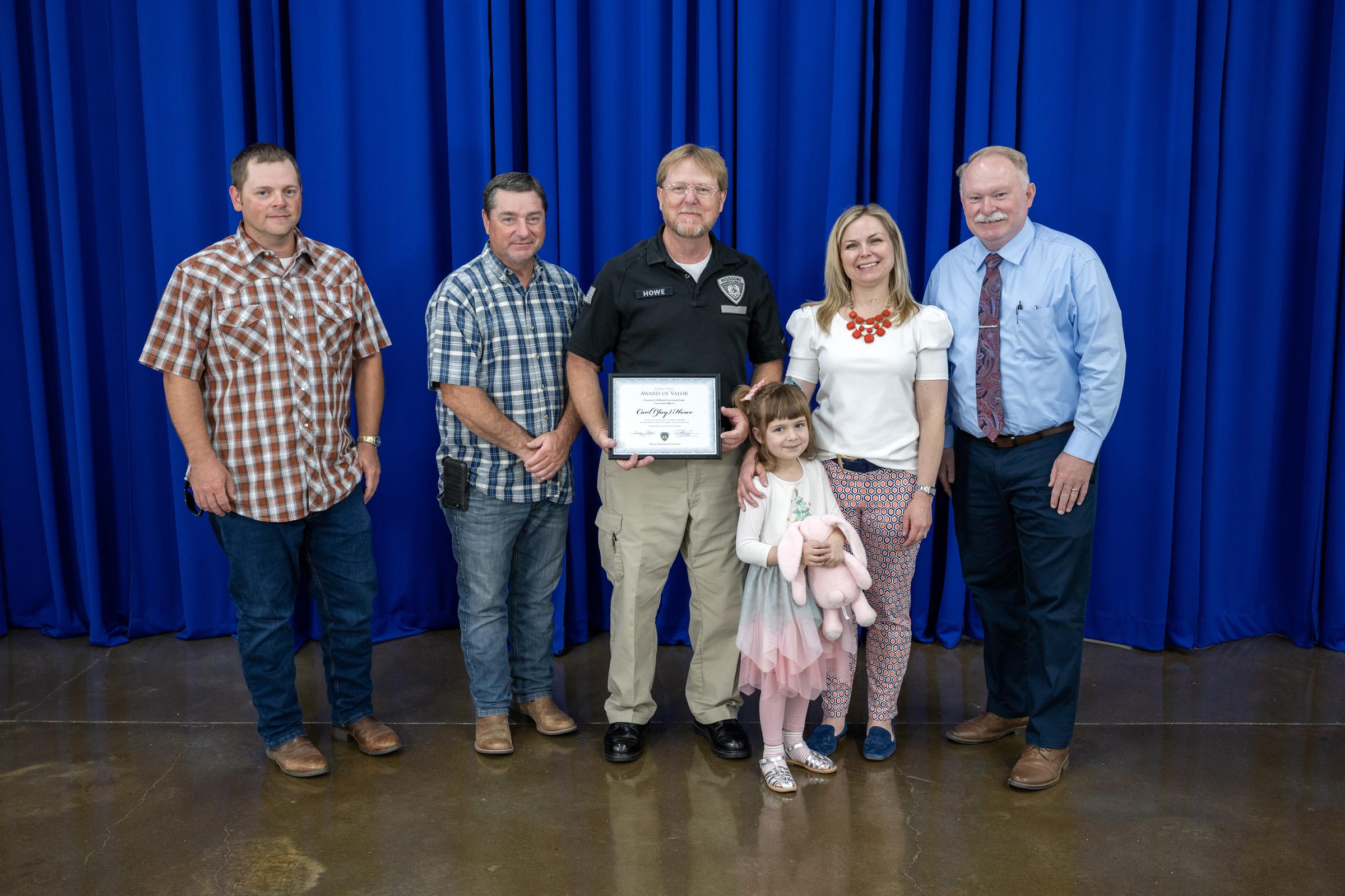Chillicothe Correctional Center Correctional Officer I Carl "Jay" Howe, with family and Warden Chris McBee